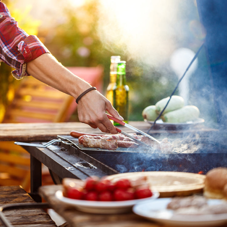 man grilling beef with smoke arising from grill